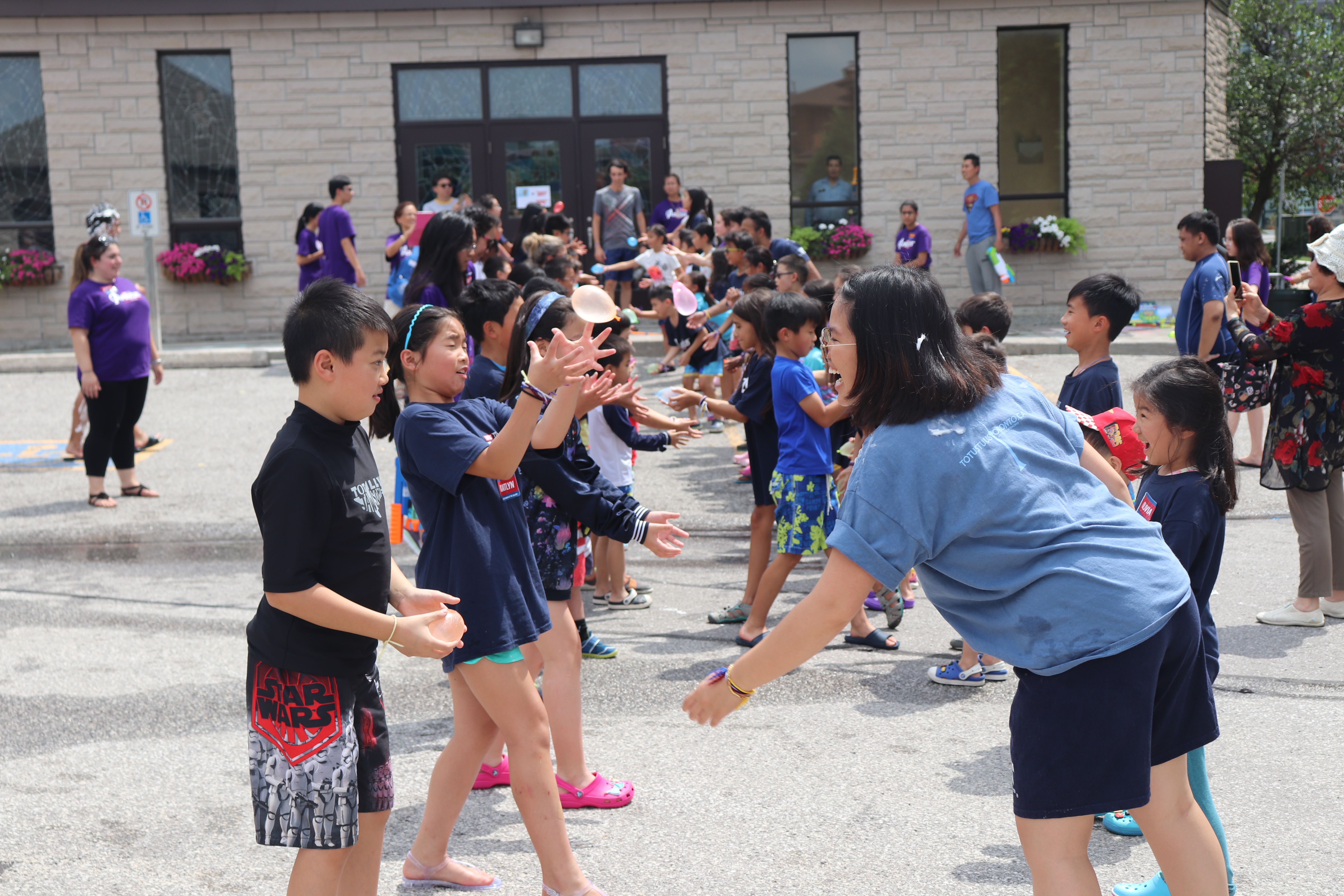 Youth leader playing games with children who are part of the summer camp